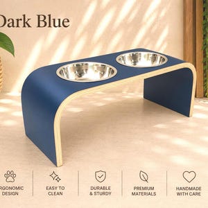 Dark blue raised wooden dog bowl stand with stainless steel bowls, handmade elevated pet feeder in a stylish contemporary home, feeding station for dogs and cats.
