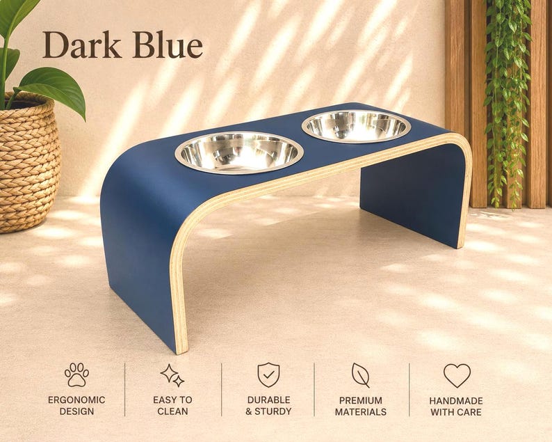 Dark blue raised wooden dog bowl stand with stainless steel bowls, handmade elevated pet feeder in a stylish contemporary home, feeding station for dogs and cats.