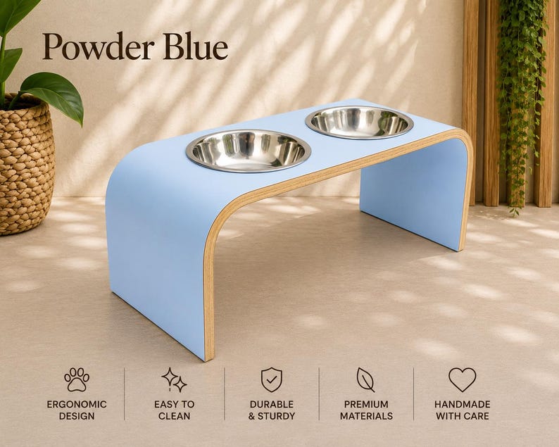 Powder blue raised wooden dog bowl stand with stainless steel bowls, handmade elevated pet feeder in a bright contemporary home, ergonomic feeding station for dogs and cats.