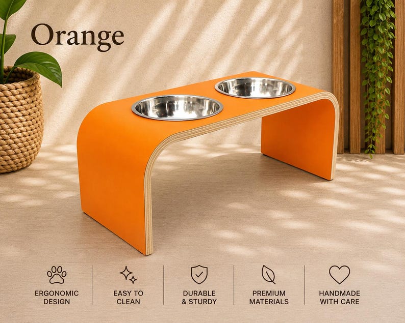 Orange elevated dog bowl stand with stainless steel bowls, handmade wooden pet feeder in a contemporary home, modern feeding station for dogs and cats.