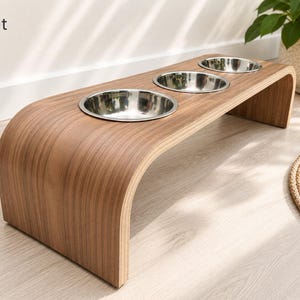 Modern walnut raised triple dog bowl stand with stainless steel bowls, handcrafted curved wooden pet feeder for dogs and cats.