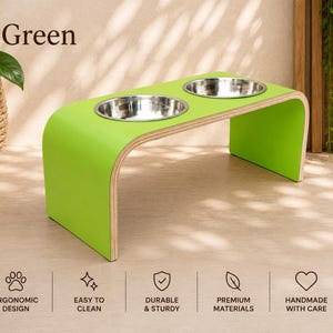 Green raised wooden dog bowl stand with stainless steel bowls, handmade elevated pet feeder in a modern interior, stylish feeding station for dogs and cats.