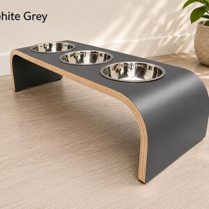 Modern graphite grey raised triple dog bowl stand with stainless steel bowls, handcrafted curved wooden pet feeder for dogs and cats.