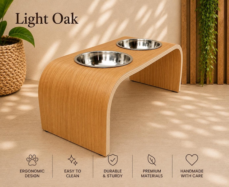 Light oak raised wooden dog bowl stand with stainless steel bowls, handmade elevated pet feeder displayed in a contemporary home, stylish feeding station for dogs and cats.