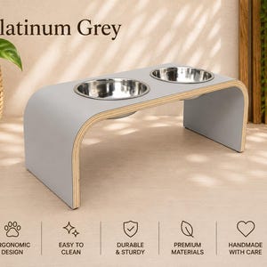Platinum grey raised dog bowl stand with stainless steel bowls, handmade elevated wooden pet feeder in a bright modern home, ergonomic feeding station for dogs and cats.