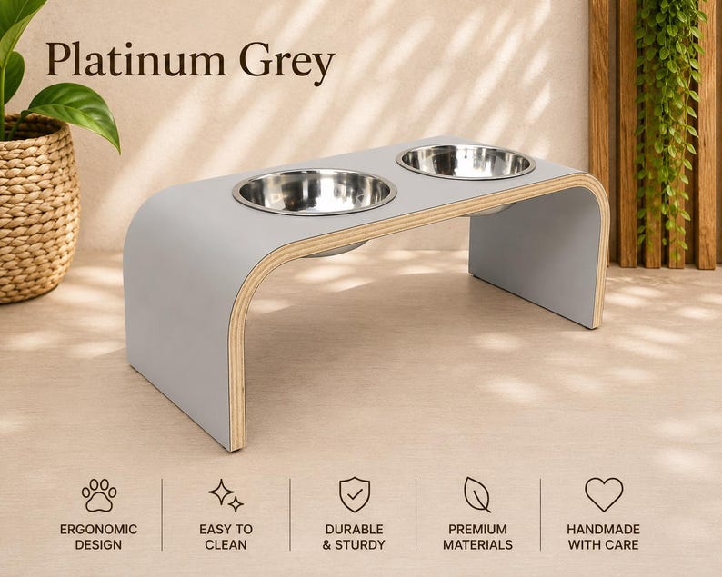 Platinum grey raised dog bowl stand with stainless steel bowls, handmade elevated wooden pet feeder in a bright modern home, ergonomic feeding station for dogs and cats.