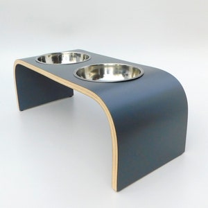 Angled view of Dark grey double raised pet feeder with stainless steel bows and natural wood edge finish.