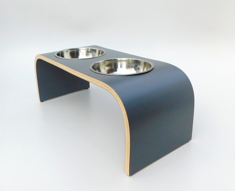 Angled view of Dark grey double raised pet feeder with stainless steel bows and natural wood edge finish.