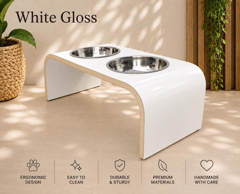 White gloss elevated dog bowl stand with two stainless steel bowls, handmade raised wooden pet feeder in a bright modern home, stylish feeding station for dogs and cats.
