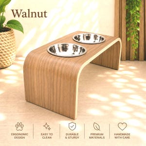 Handmade walnut raised dog bowl stand with two stainless steel bowls, elevated wooden pet feeder in a stylish modern interior, ergonomic feeding station for dogs and cats.