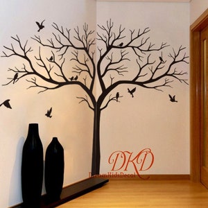 Könnte beinhalten: Schwarzer und weißer Wandaufkleber in Silhouette eines kahlen Baumes mit Vögeln auf den Ästen. Der Aufkleber befindet sich in der Ecke eines Raumes mit zwei schwarzen Vasen auf einem Regal darunter. Der Text "DKD DreamKidsDecor" ist in der unteren rechten Ecke des Bildes sichtbar.