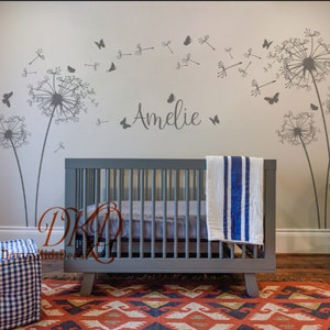 K&ouml;nnte beinhalten: Ein Kinderzimmer mit einem Babybett, einem Globus und einem Wandaufkleber mit L&ouml;wenzahnsamen, die im Wind fliegen, mit Schmetterlingen. Der Name "Amelie" steht an der Wand.