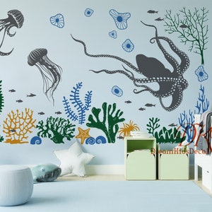 Könnte beinhalten: Ein Set an Wandaufklebern zum Thema Meer mit einem Oktopus, Quallen, Algen, Korallen und Fischen. Die Aufkleber sind in Blautönen, Grün- und Orangetönen gehalten und eignen sich perfekt für ein Kinderzimmer oder einen Spielraum.