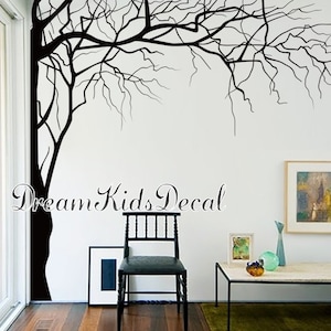 May include: Black and white silhouette wall decal of a bare tree branch extending across a white wall. The decal is partially covering a corner of the wall. The text "Dream Kids Decal" is visible on the wall.