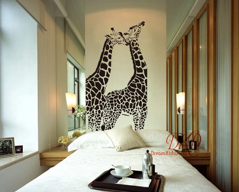 K&ouml;nnte beinhalten: Ein schwarz-wei&szlig;es Wandtattoo mit zwei sich k&uuml;ssenden Giraffen. Die Giraffen befinden sich in einem Schlafzimmer mit einem wei&szlig;en Bett und einem wei&szlig;en Nachttisch.