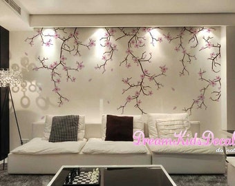 May include: A white couch with two pillows, one black and one patterned, in a living room with a wall decorated with a pink cherry blossom tree decal. The text "Dream Kids Decal do not copy" is visible in the bottom right corner of the image.