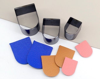 May include: Three different sizes of metal leather punch tools with a variety of leather pieces cut out using the tools. The leather pieces are blue, brown, and pink.