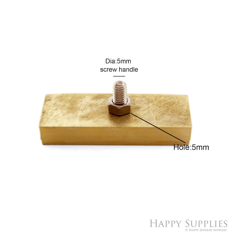 K&ouml;nnte beinhalten: Ein rechteckiger Messingblock mit einem 5 mm Schraubgriff und einem 5 mm Loch. Der Schraubgriff ist am Block befestigt.