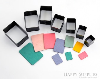 May include: Set of eight black metal rectangle leather punch tools with various sizes. The tools are shown with samples of punched leather in different colors.