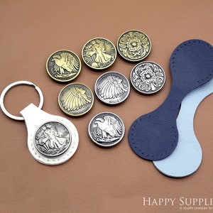 May include: Assortment of metal buttons with various designs, including a bald eagle, a Native American headdress, and floral patterns. The buttons are displayed on a brown surface with a blue and light blue leather strap.