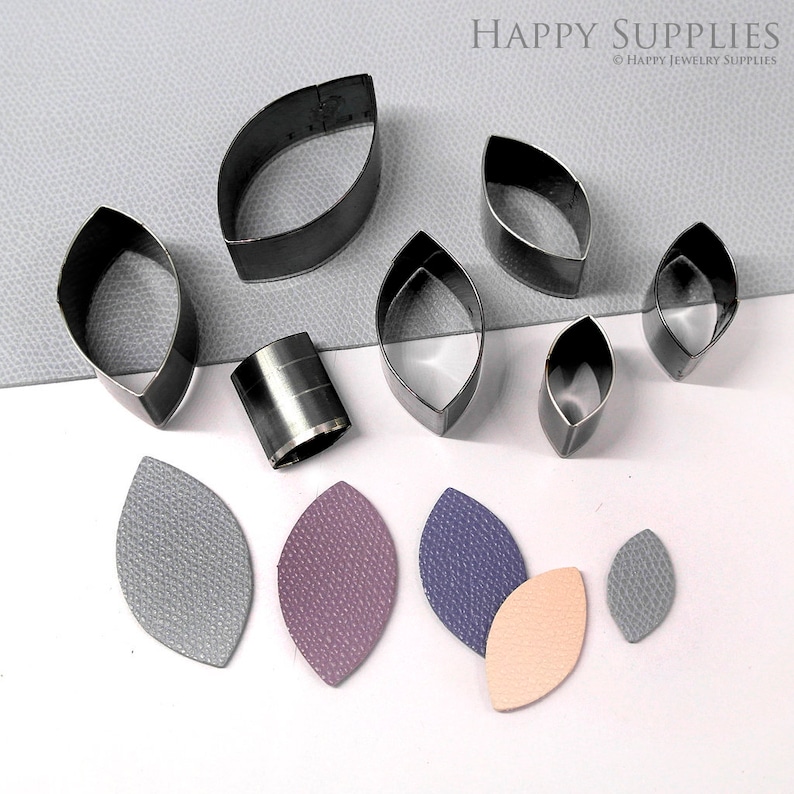 May include: A set of six metal leaf-shaped leather punches, a metal circle punch, and six leather pieces cut out in various colors, including gray, purple, and beige.  Happy Jewelry Supplies is printed on the background.