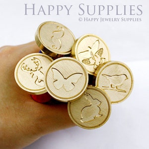 May include: A set of six gold-toned metal wax seals with various animal and insect designs. The designs include a deer, butterfly, bird, rabbit, and two different butterflies.