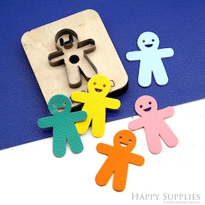 May include: A wooden die-cut tool with a gingerbread man shape, alongside several colorful leather gingerbread man cutouts in blue, yellow, green, pink, and orange. The image is on a blue surface with the words "HAPPY SUPPLIES".