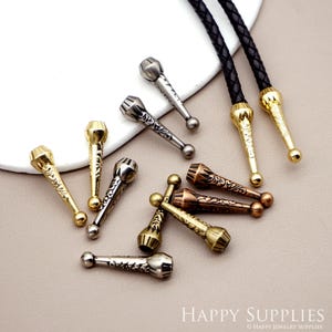 May include: A collection of decorative metal bolo tie tips in silver, gold, and bronze finishes. The tips feature intricate floral designs and are perfect for adding a touch of style to any bolo tie.