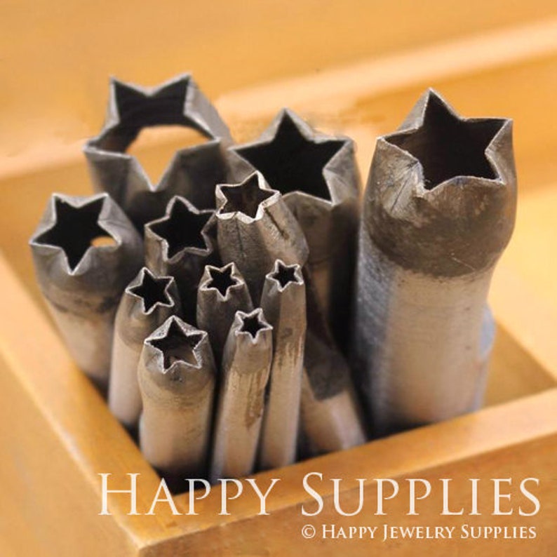 May include: A set of metal star-shaped punches in various sizes, arranged in a wooden box. The punches are used for creating decorative holes in leather, metal, or other materials.