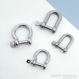 Könnte beinhalten: Vier silberne D-Ringe aus Metall in verschiedenen Größen. Die Ringe haben einen Schraubverschluss.