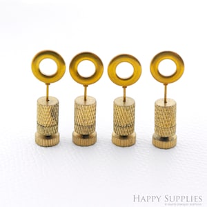 May include: Four gold-colored metal earring display stands with a round top and a threaded base. Each stand has a small ring on top.
