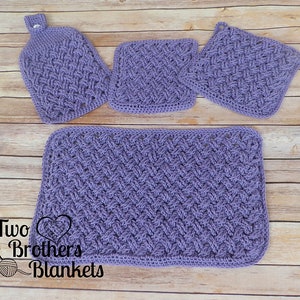 Puede incluir: Un juego de cuatro art&iacute;culos de cocina de ganchillo en tono lavanda. El conjunto incluye una toalla colgante, dos agarraderas cuadradas y un pa&ntilde;o de cocina rectangular. Los art&iacute;culos presentan un patr&oacute;n de tejido texturizado. El texto "Two Brothers Blankets" es visible.