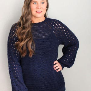 May include: A navy blue crocheted sweater with a lacy pattern on the sleeves and neckline.