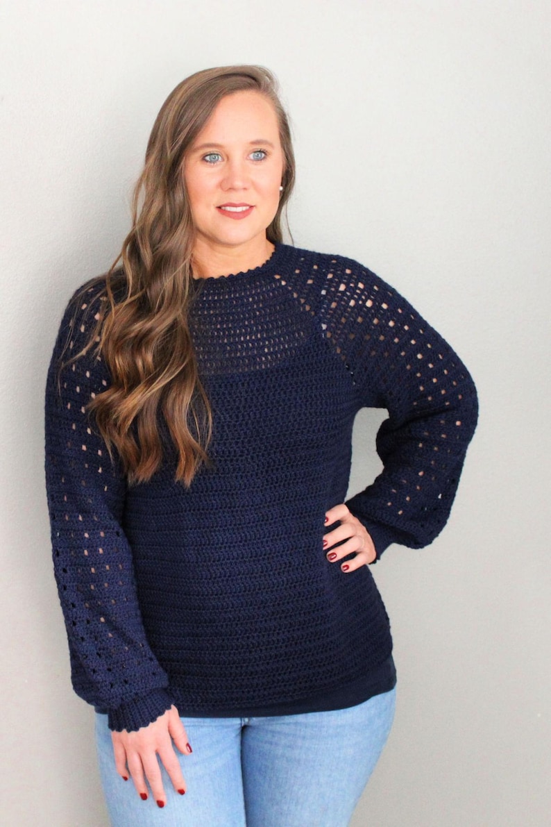 May include: A navy blue crocheted sweater with a lacy pattern on the sleeves and neckline.