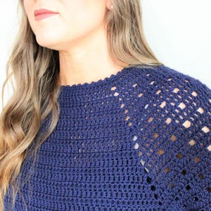 May include: A navy blue crochet top with a lacy, open-stitch design on the shoulders and neckline.