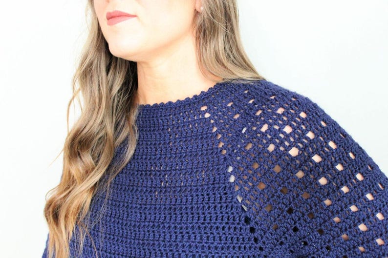 May include: A navy blue crochet top with a lacy, open-stitch design on the shoulders and neckline.
