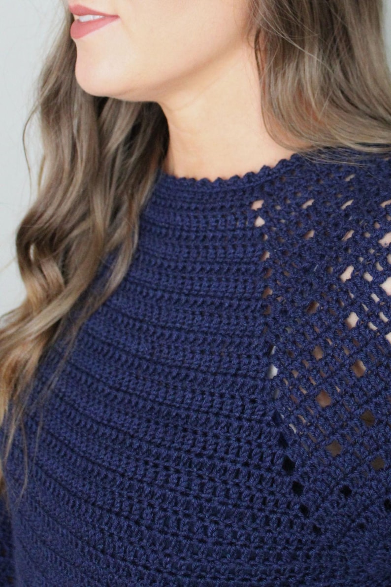 May include: A navy blue crochet sweater with a lacy design on the shoulders.