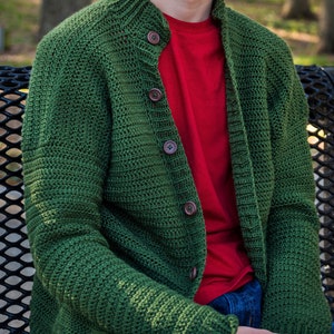 May include: A green knitted cardigan with a button-up front and long sleeves. The cardigan is made of a soft, textured yarn and has a casual, relaxed fit.