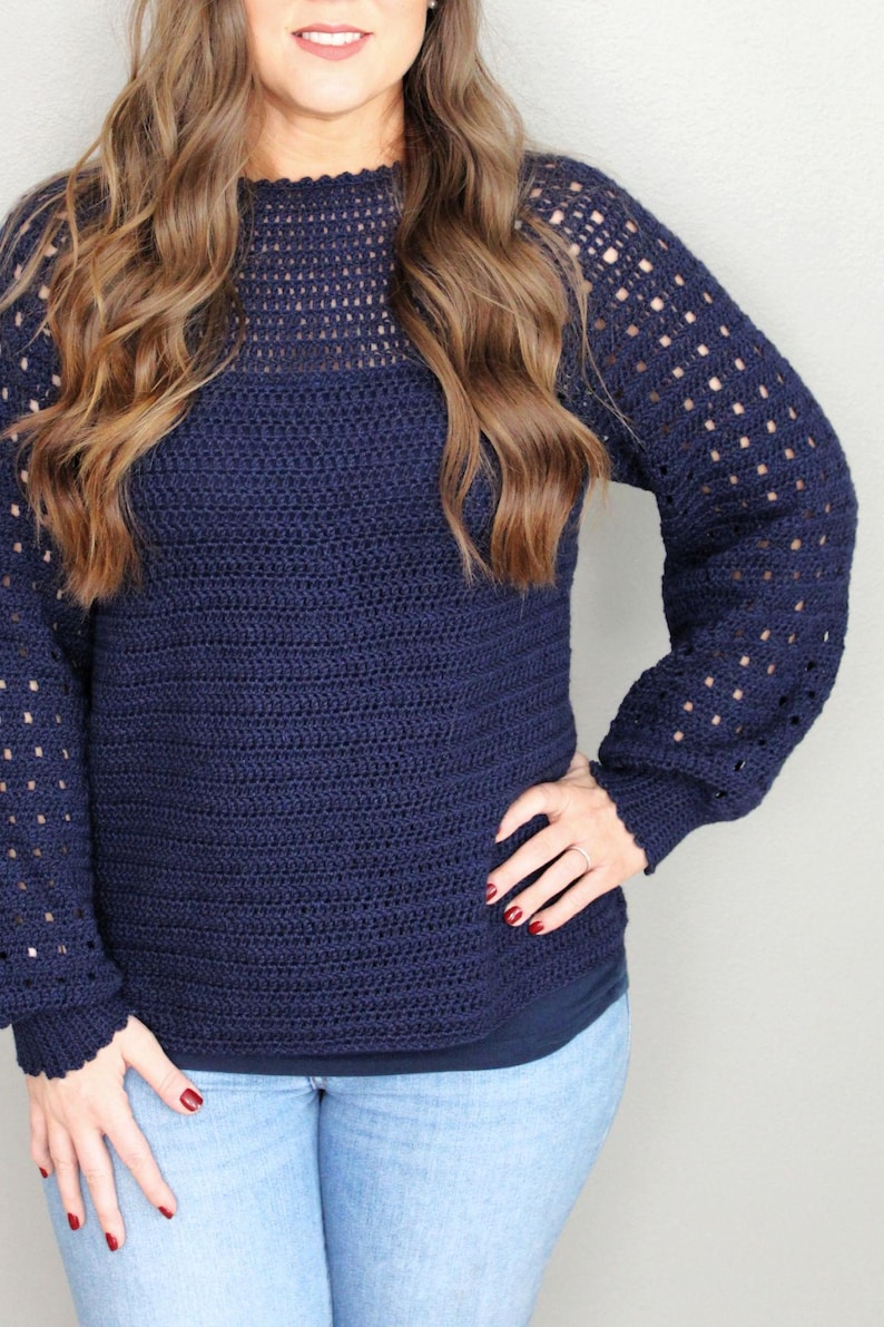 May include: A navy blue crocheted sweater with a lacy pattern on the sleeves and neckline.