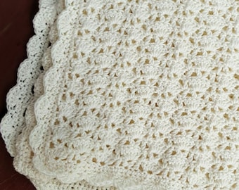 May include: A white crocheted blanket with a scalloped edge.