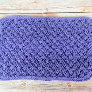 Puede incluir: Un art&iacute;culo rectangular, tejido a mano, en un suave tono lavanda. La pieza presenta un patr&oacute;n texturizado, similar al tejido, en toda su superficie. Los bordes est&aacute;n cuidadosamente acabados. Podr&iacute;a ser un pa&ntilde;o de cocina o una peque&ntilde;a manta.