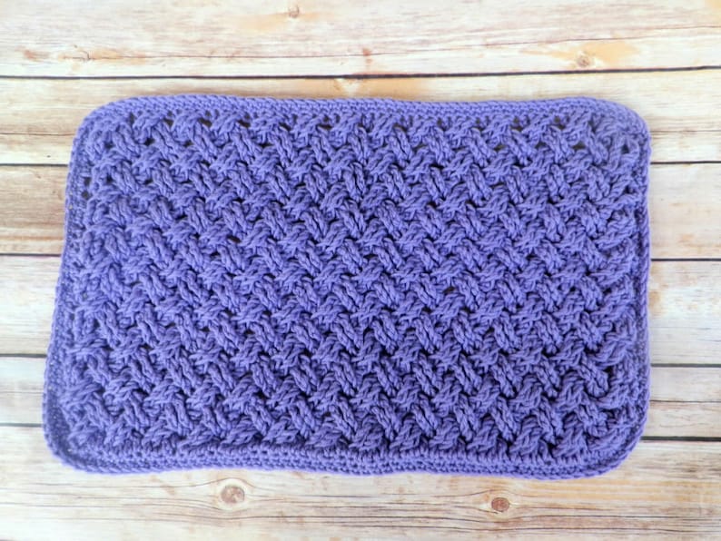 Puede incluir: Un art&iacute;culo rectangular, tejido a mano, en un suave tono lavanda. La pieza presenta un patr&oacute;n texturizado, similar al tejido, en toda su superficie. Los bordes est&aacute;n cuidadosamente acabados. Podr&iacute;a ser un pa&ntilde;o de cocina o una peque&ntilde;a manta.