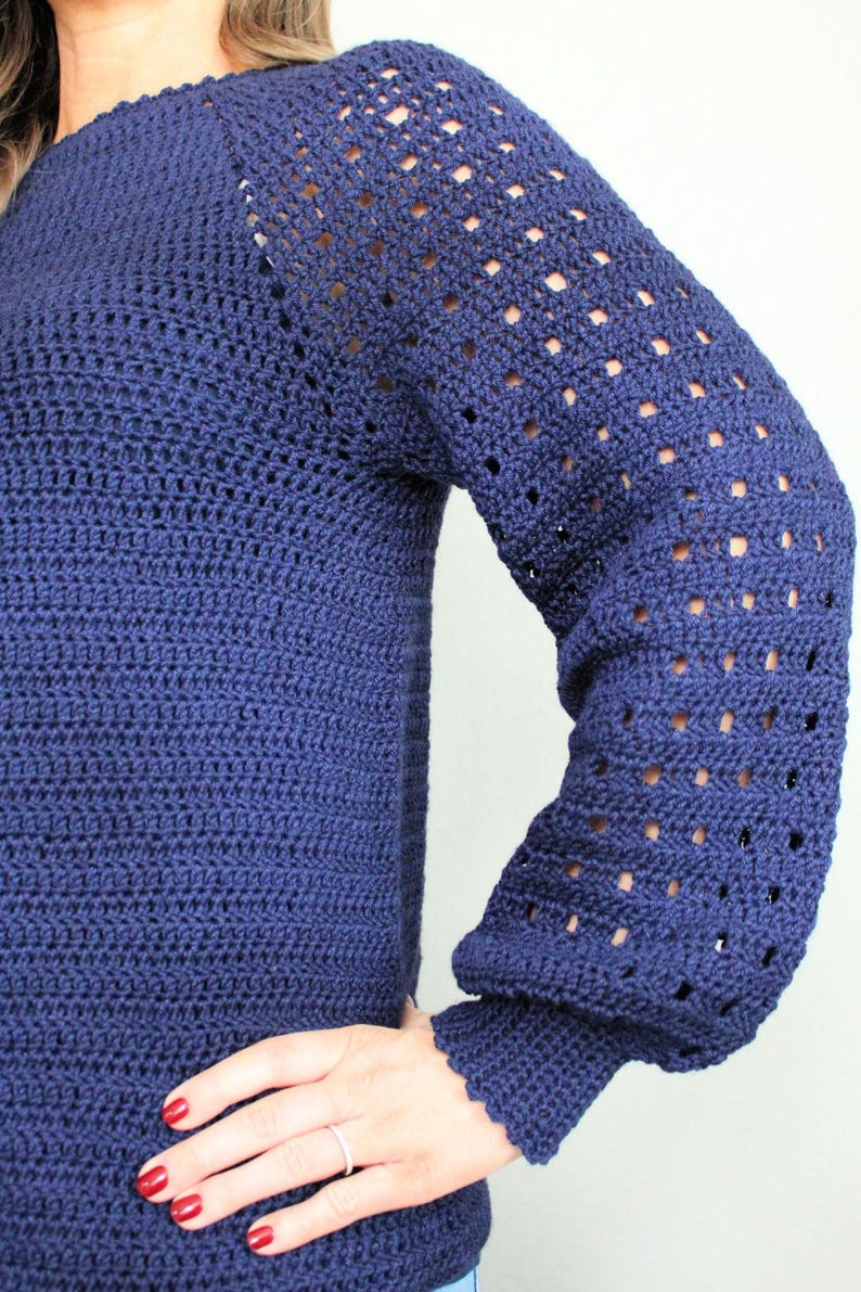 May include: A navy blue crocheted sweater with a lacy pattern on the sleeves.