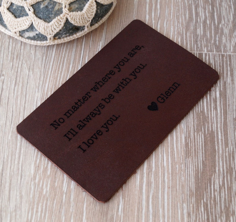 May include: A brown leather card with the text "No matter where you are, I'll always be with you. I love you." and the name "Glenn" engraved on it.