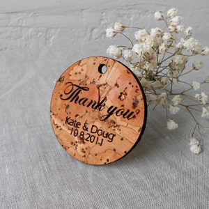 May include: Round cork thank you tag with the text "Thank you" in cursive script, followed by "Kate & Doug" and the date "10.8.2011".
