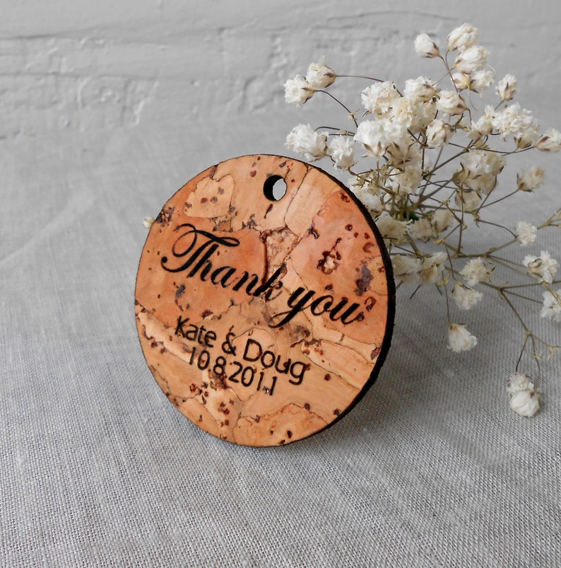 May include: Round cork thank you tag with the text "Thank you" in cursive script, followed by "Kate & Doug" and the date "10.8.2011".