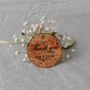 May include: Round cork thank you tag with the text "Thank you" in cursive, "Kate & Doug" and the date "10.8.2011".