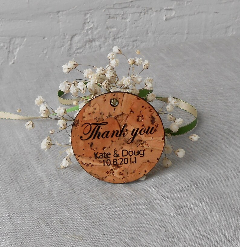 May include: Round cork thank you tag with the text "Thank you" in cursive, "Kate & Doug" and the date "10.8.2011".
