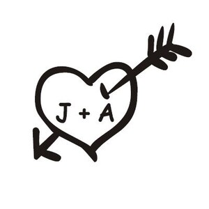 Peut inclure: Une illustration en noir et blanc d'un cœur transpercé par une flèche. Le cœur contient le texte "J + A".