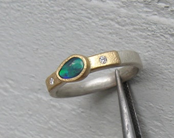 Feiner Ring mit Schwarzopal und Diamanten in 750er Gold und Sterlingsilber.